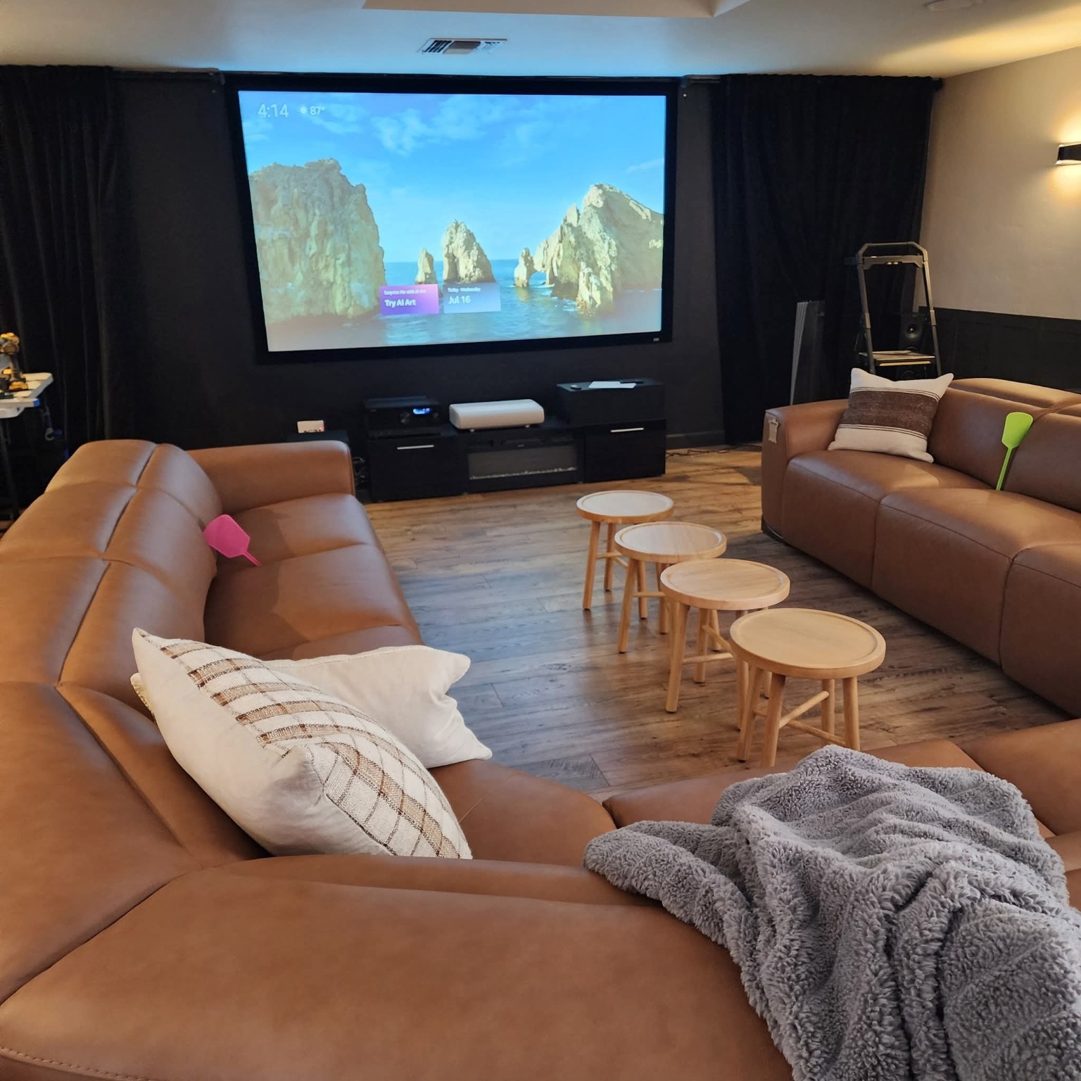 Home theater with tan couches and projection screen