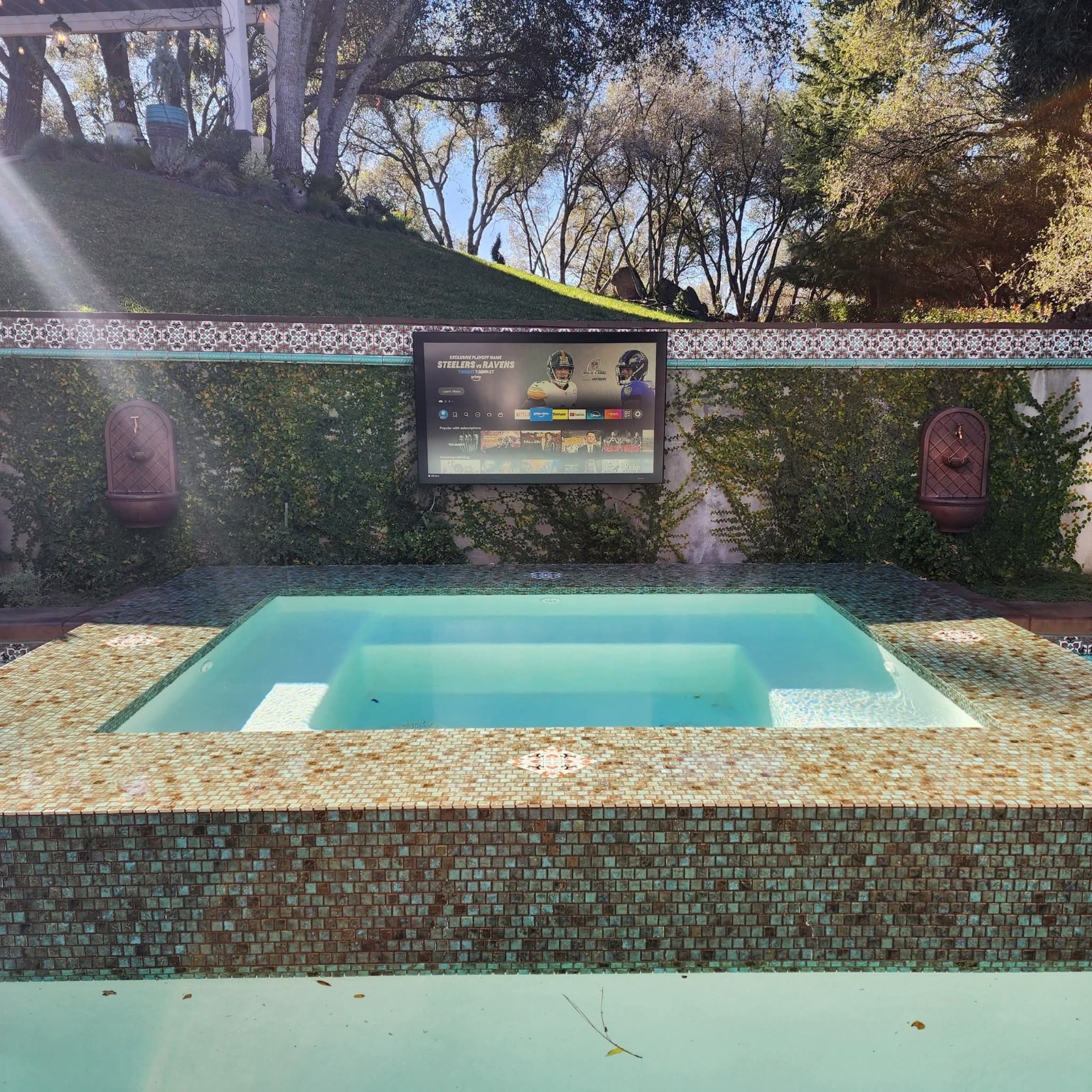 Outdoor TV installation by a pool and spa